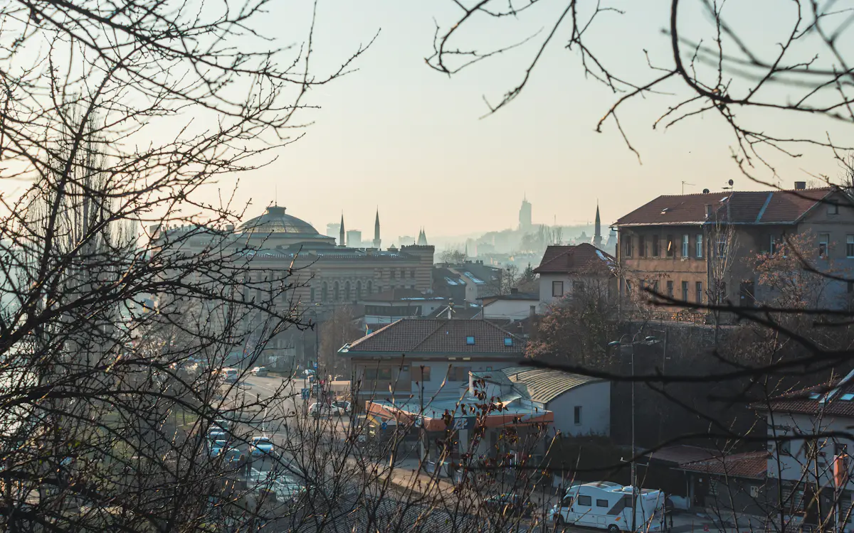 Bruma matinal sobre Sarajevo, en Bosnia y Herzegovina, con la cúpula del Ayuntamiento y los minaretes en el valle