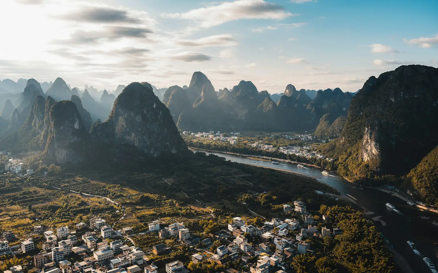 Karst peaks above the river and village at sunrise, Yangshuo, Guangxi, China