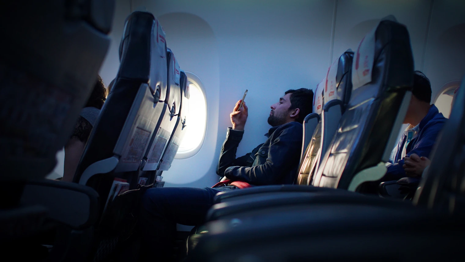 A traveller checking phone settings during a flight
