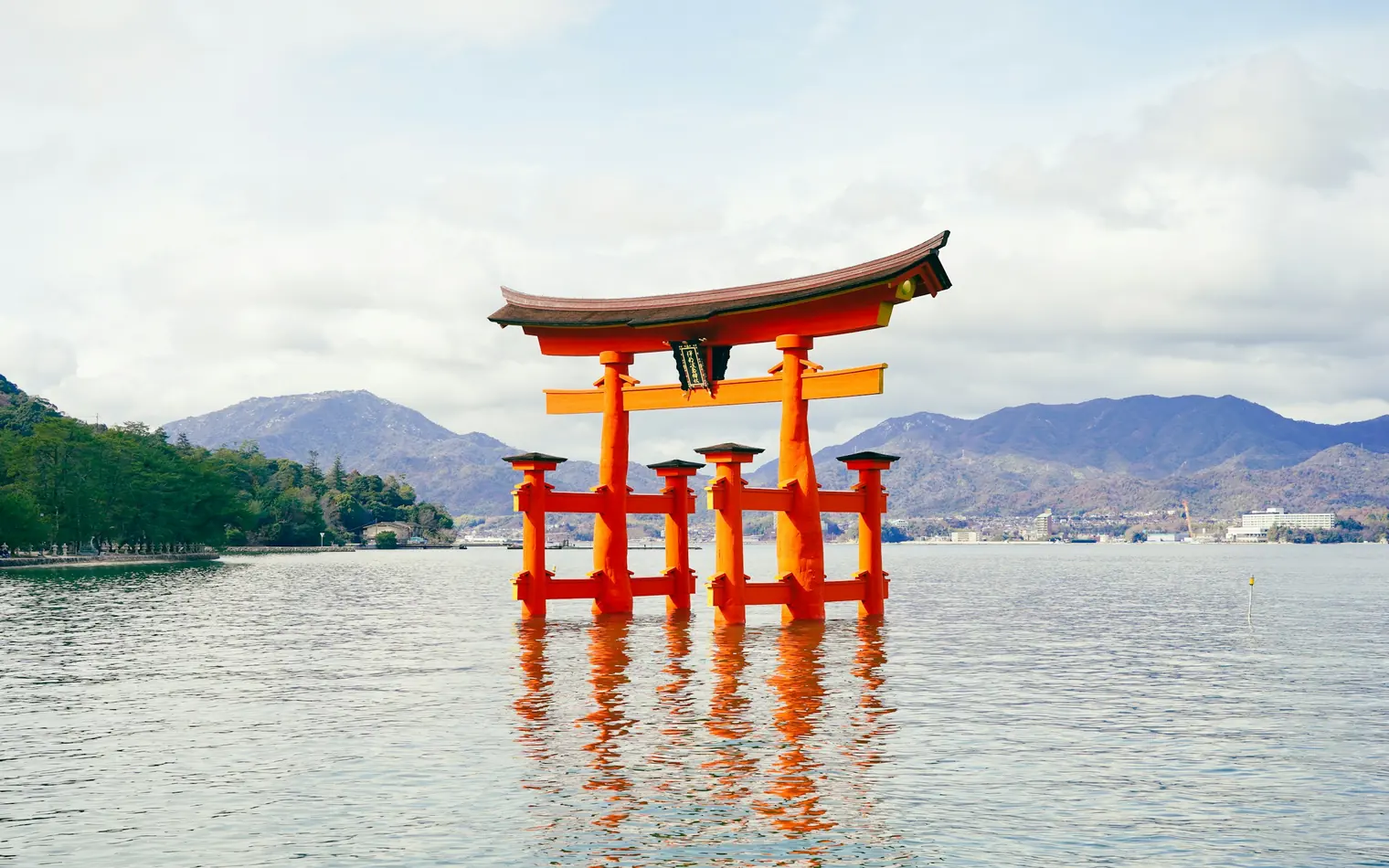The torii gate of Itsukushima Shrine standing in the sea at high tide, Miyajima, Japan