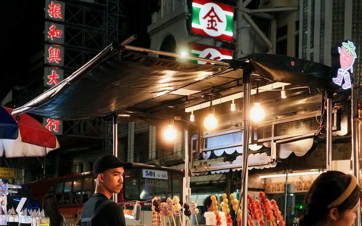 A street-food stall under neon signs on Yaowarat Road, Bangkok's Chinatown, Thailand