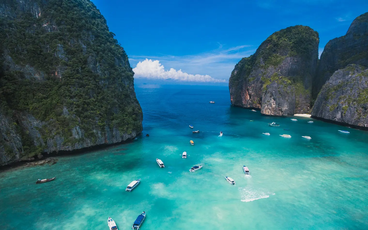 Boats on the turquoise water of Maya Bay between limestone cliffs, Koh Phi Phi, Thailand